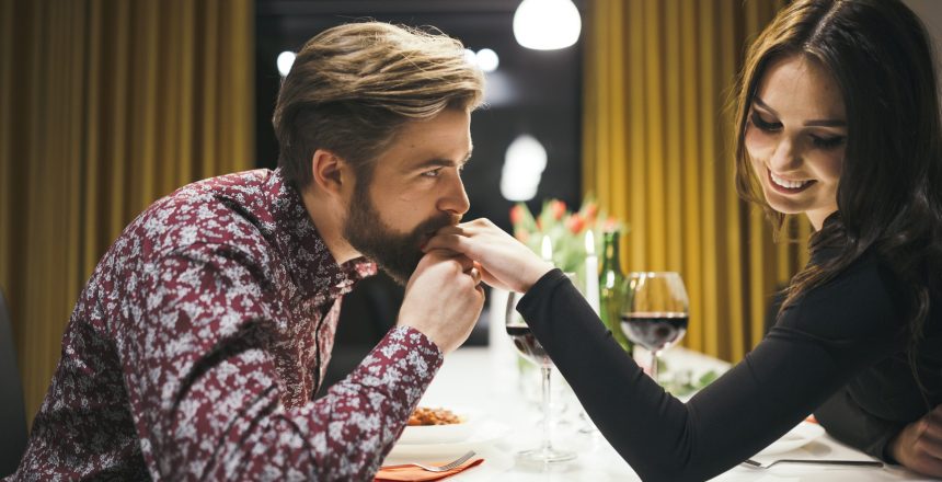 Couple au restaurant et homme embrassant la main de sa compagne